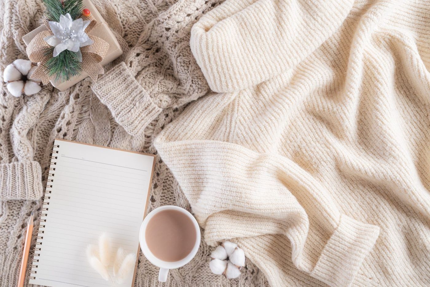 A soft knitted blanket, a notebook and a cup of tea